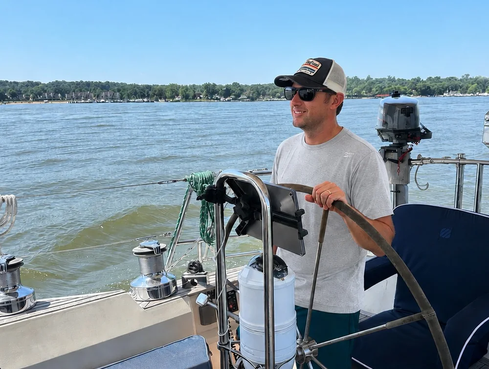 Brian Rosensteel at the helm of a cruising sailboat